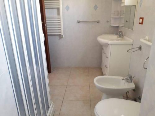 nonna Tomasina في بورتو بوزو: حمام ابيض مع مرحاض ومغسلة