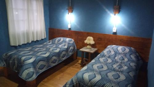 a room with two beds and a table and lights at Lo de la Abuela in Goya