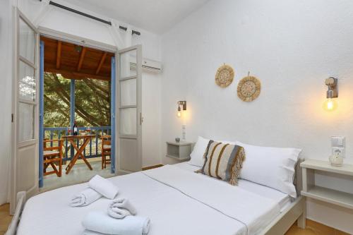 a bedroom with a white bed with towels on it at Skopelos Panos Studios in Stafylos