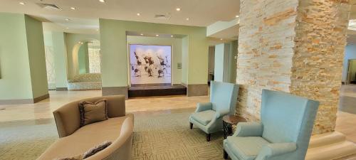 a lobby with two chairs and a painting on the wall at Sapphire 1706 in South Padre Island
