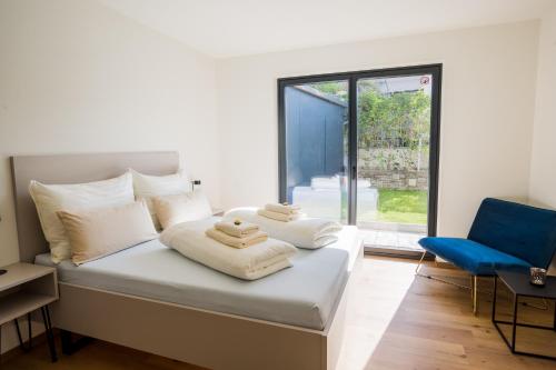 ein Schlafzimmer mit einem Bett und einem blauen Stuhl in der Unterkunft Moderne Wohnung mit Terrasse in Innsbruck
