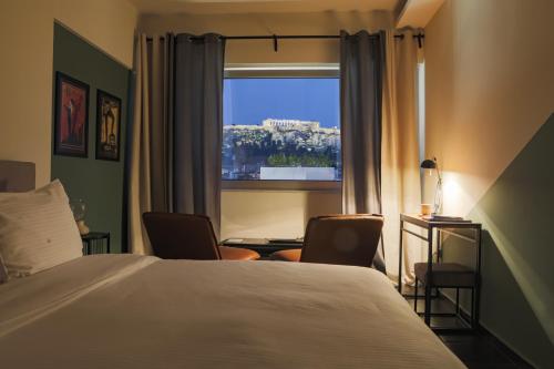 a hotel room with a bed and a window at Elite Ermou Suites in Athens