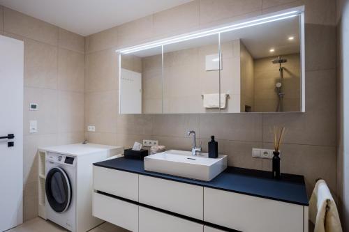 een badkamer met een wastafel en een wasmachine bij Moderne Wohnung mit Terrasse in Innsbruck