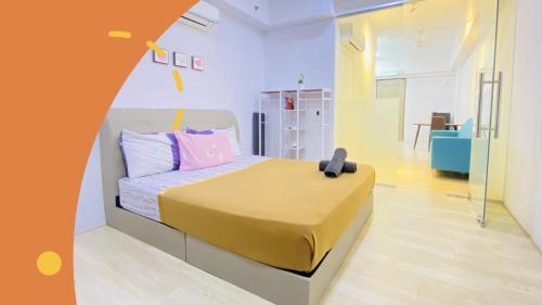 a bedroom with a bed with a yellow blanket on it at Revo-Pavilion-Bukit Jalil in Kuala Lumpur