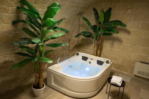 a bathroom with a bath tub and two palm trees at 2 Love rooms in Corato