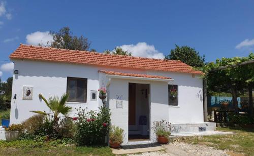 a small white house with a red roof at The Cottage near the lake in Pedrógão Grande