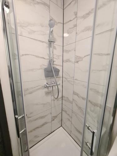 a shower with a glass door in a bathroom at Homestay by BIC Oates 4 in Dewsbury