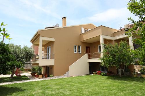 een groot huis met een gazon ervoor bij Fou's apartment in Nafpaktos