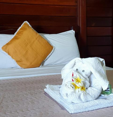 a towel animal with a flower on a bed at Pousada Recanto Verdes Mares in Arraial do Cabo