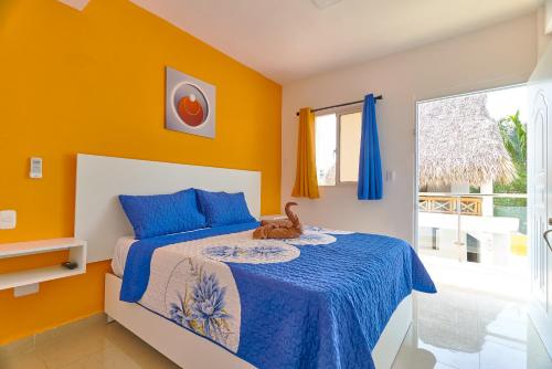 Schlafzimmer mit einem Bett mit blauen und orangefarbenen Wänden in der Unterkunft Sun Express Hotel in Pueblo Bávaro