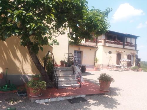a house with stairs and a tree in front of it at torreprima1 in San Gimignano