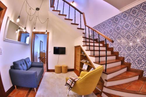 - un salon avec un escalier et un canapé bleu dans l'établissement Apartamentos Francisco Martins, à Vila Franca do Campo