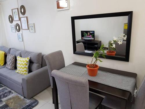 een woonkamer met een bank, een tafel en een spiegel bij Entire Unit Fully Air-conditioned with Hi-Speed WiFi in Mabalacat