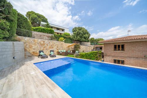 a swimming pool in the backyard of a house at Villa Santa Cristina Lux, Ideal Familias, frente al Mar - Cala Treumal in Blanes