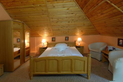 1 dormitorio con 1 cama grande y techo de madera en Villa Hera, en Băile Herculane