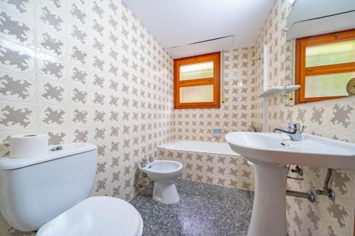 uma casa de banho com um WC e um lavatório em Villa Santa Cristina Lux, Ideal Familias, frente al Mar - Cala Treumal em Blanes