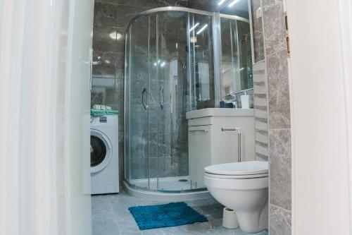 a bathroom with a toilet and a shower and a washing machine at Flexible SelfCheckIns 52 - Zagreb - Parking - Loggia in Zagreb