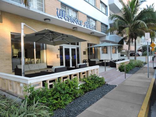 a restaurant with tables and umbrellas in front of a building at Westover Arms Hotel in Miami Beach