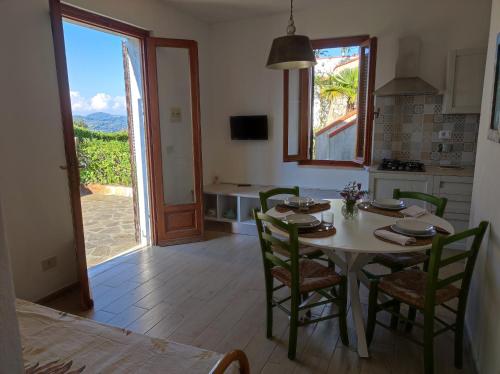 een keuken en eetkamer met een tafel en stoelen bij I SALICI in Capoliveri