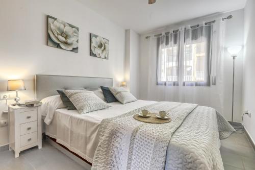 - une chambre blanche avec un lit et un plateau dans l'établissement Gran Reserva Mimoses 1 D - Immo Barneda, à Empuriabrava