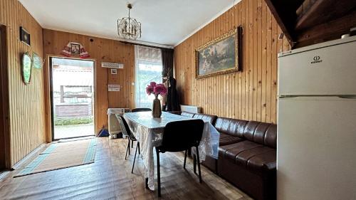 uma sala de estar com um sofá, uma mesa e um frigorífico em Ny to Abzatc em Slavske