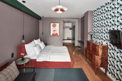 a small bedroom with a bed and a couch at Bez Kantów Art Rooms in Warsaw