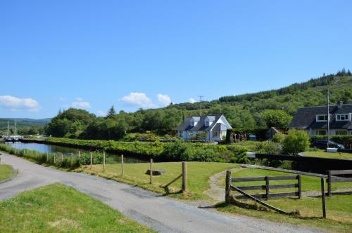 a winding road next to a river with houses at Cairnbaan House in Cairnbaan