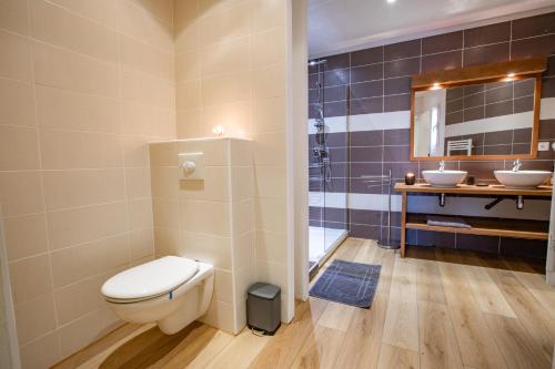 La salle de bains est pourvue de toilettes et de 2 lavabos. dans l'établissement Appartement dans résidence pieds dans l’eau, au Trayas
