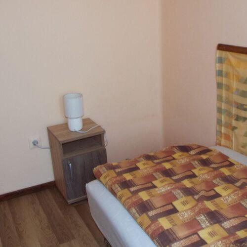 a bedroom with a bed and a nightstand with a bed sidx sidx at Panna Vendégház Sárospatak in Sárospatak