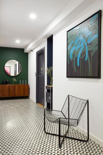 a chair in a room with a painting on the wall at Bez Kantów Art Rooms in Warsaw