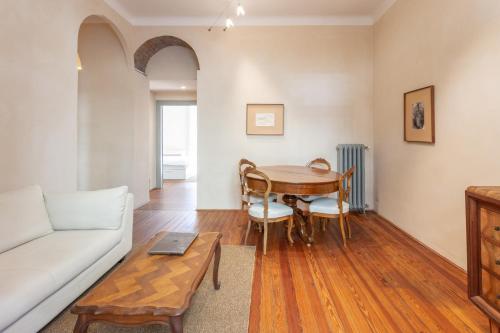 een woonkamer met een bank en een tafel bij Suite Cavour by iCasamia in Varese