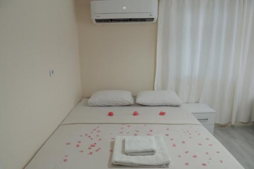 a small room with a bed with flowers on it at Mavi Apart in Demre