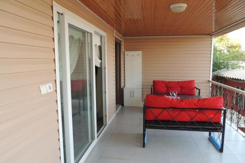 a porch with a red couch on a balcony at Mavi Apart in Demre