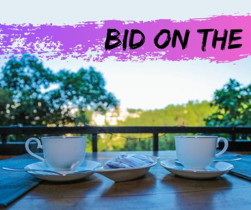 two coffee cups on a wooden table with the words big on at Kandyan Hideout in Kandy