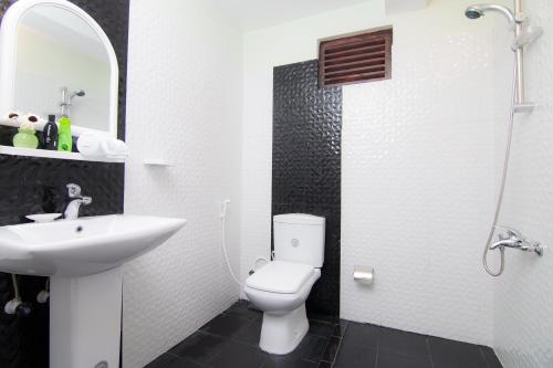 a bathroom with a white toilet and a sink at Kandyan Hideout in Kandy