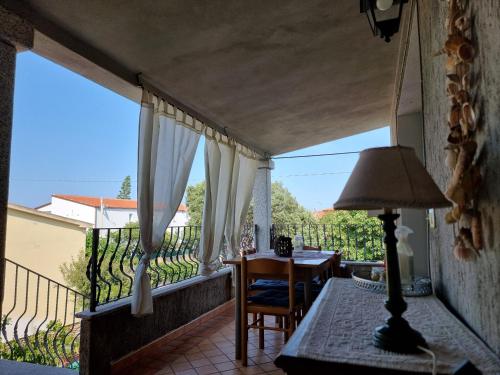 een balkon met een tafel en een lamp erop bij LEO'S HOUSE in Budoni