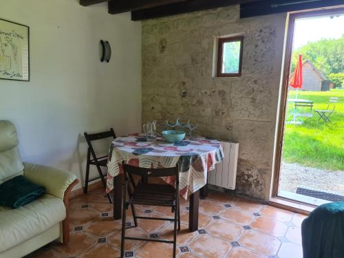 une salle à manger avec une table et un canapé dans l'établissement Petite Maison de campagne, à Fauguernon