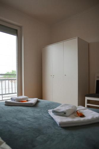 a bedroom with a bed with towels on it at CROWN apartment 2 in Subotica