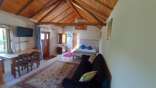 a living room with a couch and a bed and a table at The Cottage near the lake in Pedrógão Grande