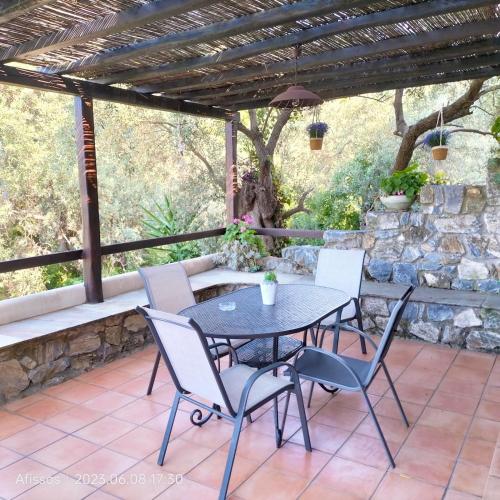 a patio with a table and chairs under a pergola at Villas On The Rock Afissos in Afissos