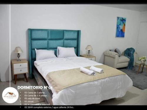 1 dormitorio con 1 cama grande y 2 toallas. en Hospedaje La Melit en Tacna