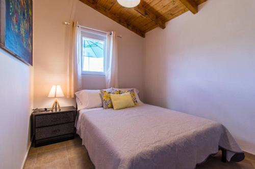 a small bedroom with a bed and a window at Little Artemis Cozy Cottage in Argos