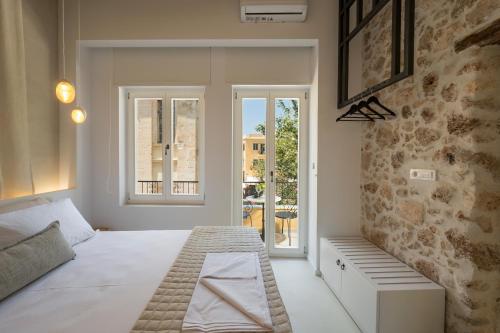 een witte slaapkamer met een bed en een raam bij il Campanile Luxury Living in Chania