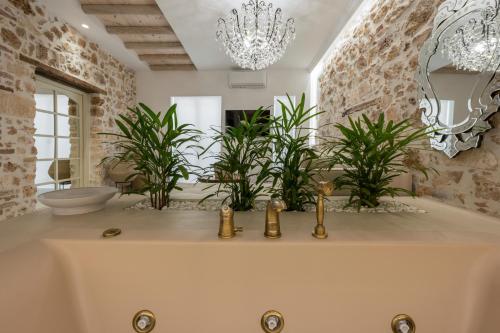 a bathroom with a tub with plants and a chandelier at il Campanile Luxury Living in Chania Town