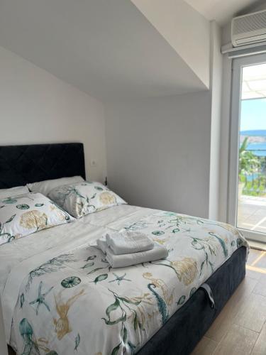 a bedroom with a bed with a floral comforter and a window at Calypso in Trogir