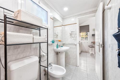 La salle de bains blanche est pourvue de toilettes et d'un lavabo. dans l'établissement Bungalow Casa Pablo, à San Bartolomé
