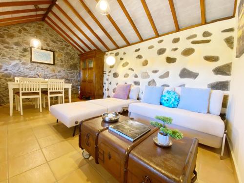 El Pirguan Holiday House, your oasis in La Gomera في فاليهيرموسو: غرفة معيشة مع أريكة وطاولة