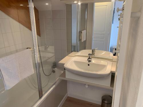 La salle de bains blanche est pourvue d'un lavabo et d'une douche. dans l'établissement Le Flocon d'Aurouze 522, Appartement 4 personnes, La Joue du Loup, à Saint-Étienne-en-Dévoluy