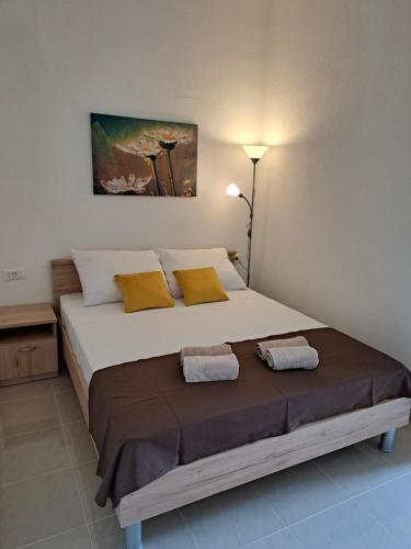 una camera da letto con un grande letto bianco con cuscini gialli di Apartman Polegubic a Biograd na Moru