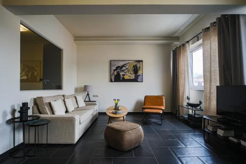 a living room with a couch and a tv at Elite Ermou Suites in Athens